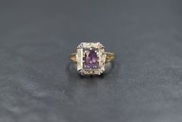 A 9ct gold amethyst and diamond set cluster ring, the central oval cut amethyst in a ten claw