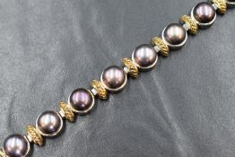 A silver and pearl set bracelet, the cultured split pearls having a black lustre in bezel settings