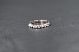 A platinum diamond set half eternity band, the nine round brilliant cut diamonds measuring