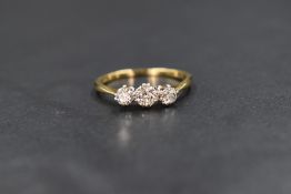An 18ct gold diamond set trilogy ring having three old cut diamonds in claw set mounts, total