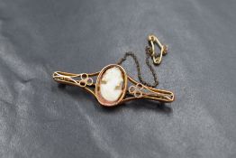 A 9ct gold cameo bar brooch, the replacement cameo glued to a bezel setting in a pierced design,