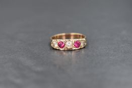 A 9ct gold ruby and white gemstone set ring, the two round cut rubies interspered with three clear