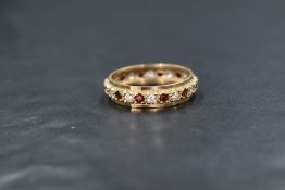 A 9ct gold garnet and cubic zirconia set full eternity ring, the alternating round cut garnets and