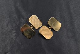 A pair of 9ct gold cufflinks, the rectangular panels with one side having engine turned decoration