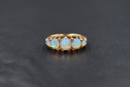 An 18ct gold opal set five stone ring, the graduated opal circular cabochons in claw setting with