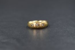 An 18ct gold diamond set gypsy ring, the three graduated old cut diamonds in star motif settings,
