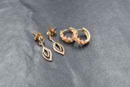 Two pairs of yellow metal earrings for pierced ears, one pair being of hoop design, the other