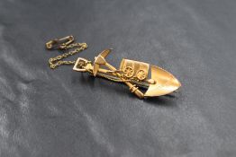 A Victorian South African miners brooch stamped 9ct depicting a station wagon, pick axe and spade