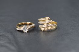 A 14ct gold cross over ring having four channel set terminals each containing ten small cubic