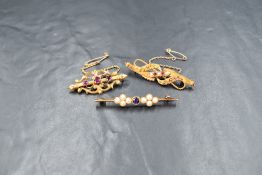 A 15ct gold ruby and pearl set brooch, the two round cut rubies interspered with two split pearls in