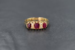 An 18ct gold ruby and diamond ring, the three graduated oval cut rubies interspersed with four old