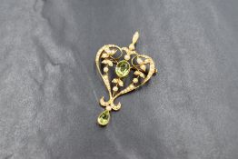 An Edwardian 15ct gold peridot and seed pearl set pendant/brooch, the central oval cut peridot in