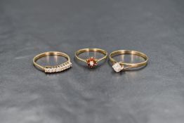 Three 9ct gold rings, comprising an opal and garnet cluster ring, a cubic zirconia solitaire and a