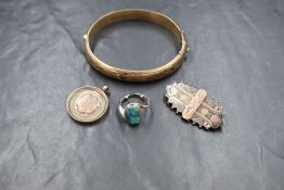 A silver hinged bracelet having decorative engraving, along with a Victorian silver floral brooch, a