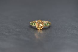 A 9ct gold citrine and green paste set ring, the central oval cut citrine measuring approximately