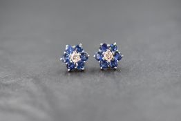 A pair of white metal presumed gold diamond and sapphire set cluster stud earrings, the central