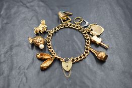 A 9ct gold curb link charm bracelet, marked 375, having a 9ct gold heart padlock marked 375, and