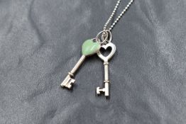 A Tiffany & Co silver bead link chain having two Tiffany key charm pendants, one having turquoise