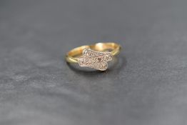 An 18ct diamond chip set ring, the six illusion set diamonds in a cross over style setting, marked