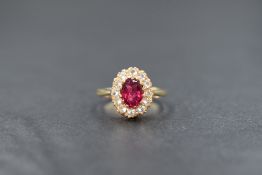 A 9ct gold cluster ring having a pink central paste stone within a surround of clear paste stones,