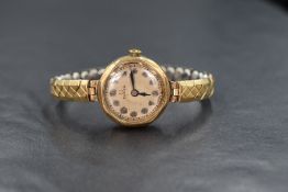 A 9ct gold cased vintage Omega wristwatch, the champagne dial having Arabic numerals, on a rolled