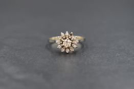 A white metal presumed gold diamond cluster ring, the central diamond measuring approximately 0.