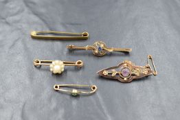 A collection of five yellow metal and gold brooches, including gem and pearl set examples, marks