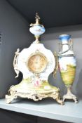 A Franz Hermle (Germany) porcelain mantel clock and garniture, hand coloured with playful cherbs