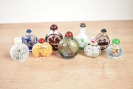 A group of Chinese glass snuff bottles decorated with scenes of exotic bird's and everyday genre