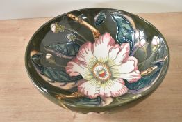 A Moorcroft pottery 'Gustavia' pattern bowl having tube line decoration and raised on a circular