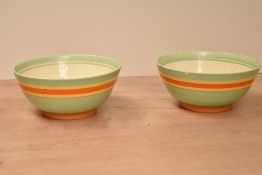 A pair of Clarice Cliff for Newport pottery bowls, decorated with yellow and orange stripes on a