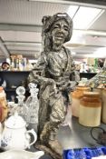 A large continental cast resin figure depicting an armed male leaning up against a tree, signed R,