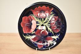 A Moorcroft 'Anemore' pattern pottery plate having tube line decoration, impressed and painted marks