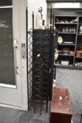 A free standing 36 bottle metal wine rack having finial top, h168cm, sold together with another wine