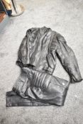 A leather motorbike jacket, size 44, sold together with a pair of leather trousers, size 32 waist