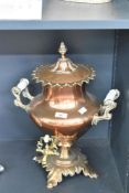 A 19th century brass samovar, having white ceramic handles with rococo scrolling and copper tap,