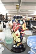A Moorcroft pottery 'Pomegranate' pattern table lamp of lobed form, raised on a circular base,