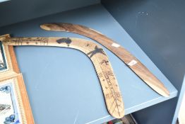 An Australian wooden boomerang having carved figures and traditional aboriginal patterns, L51cm,