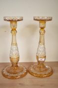 An attractive pair of Bohemian style cut crystal candlesticks, decorated with fruit and foliage on a