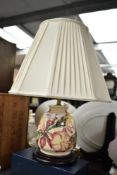 A Moorcroft pottery 'Frangipani/Magnolia' pattern table lamp with shade, raised on a circular