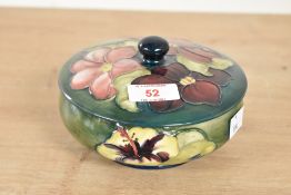 A Moorcroft pottery 'Hibiscus' pattern trinket with cover, having tub lined floral decoration on a