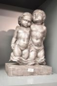 A winged cherub group, 'the Cherubs', patinated resin, on a rectangular plinth, h43cm *purchased