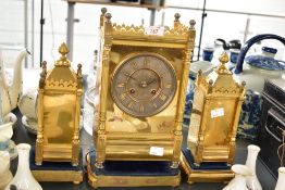 A French 8-day brass mantel clock and garnitures, having brass dial with Roman numerals, mounted by