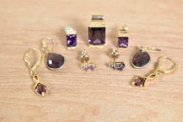 A small collection of purple paste costume jewellery, including pendants and earrings