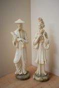 Two oriental cast composition figures depicting a male holding a scroll and a female holding a