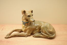 A large amateur pottery study of a Greyhound in a laid down position, bearing no markings or
