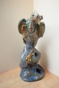 A large pottery animal study depicting a grotesque bird mounted on a rock, damages to bird's
