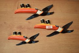 A set of three porcelain Guinness flying toucan wall plaques, descending in size, bearing no