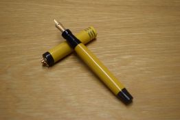 A Parker Duofold vest pocket button fill fountain pen in Mandarin Yellow with three gold bands to