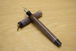 A Parker Duofold Lucky Curve button fill fountain pen in Mauve Moire with a two cap bands on a